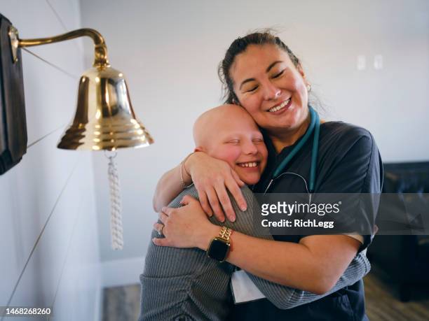 child chemotherapy patient finishing treatment with a ceremonial bell ring - ringing bell stock pictures, royalty-free photos & images