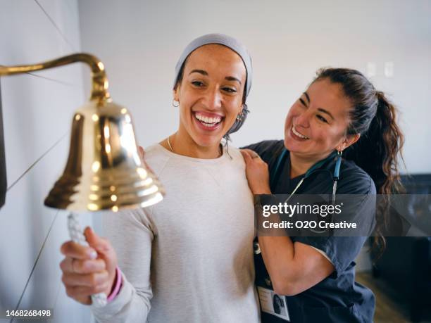 paziente adulto di chemioterapia della donna che termina il trattamento con un suono cerimoniale della campana - campana foto e immagini stock