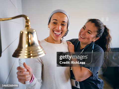 Adult Woman Chemotherapy Patient Finishing Treatment with a Ceremonial Bell Ring