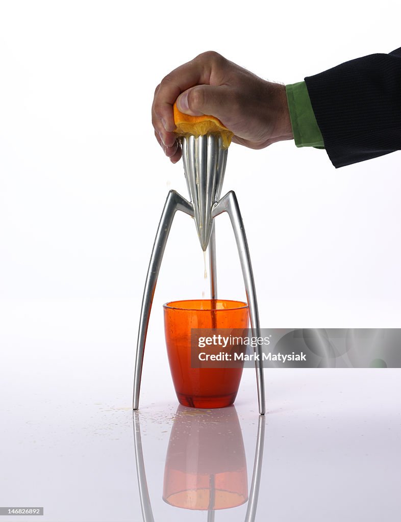 Man squeezing orange juice with retro juicer