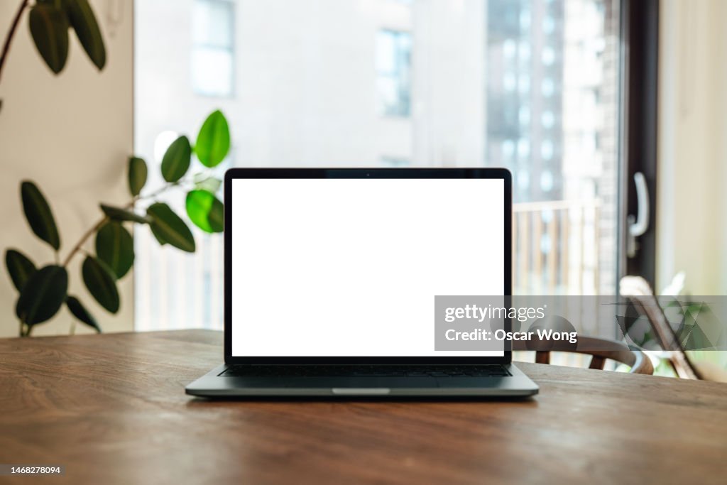 A laptop with blank screen on wooden table in the living room