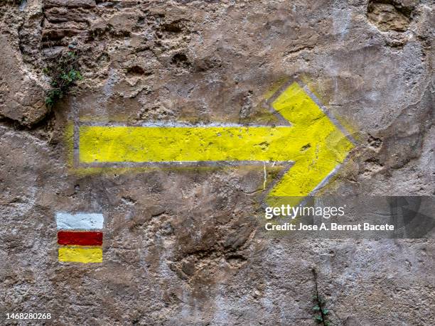 directional arrow sign on a wall on a gr mountain trail. - arrows landscapes stock pictures, royalty-free photos & images