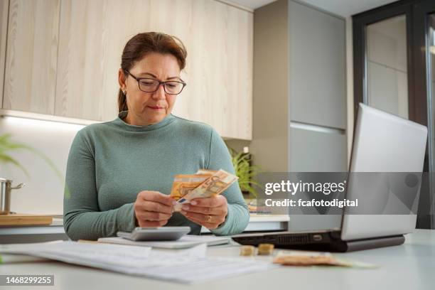 mujer contando dinero calculando gastos del hogar - banco de españa fotografías e imágenes de stock