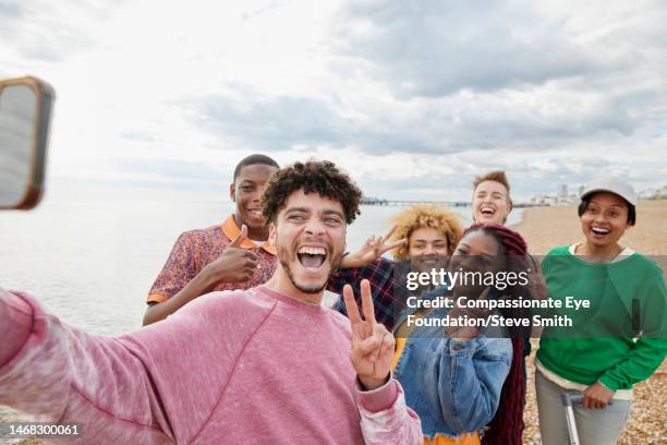 group of friends taking selfie on sunny beach - phone a friend stock pictures, royalty-free photos & images