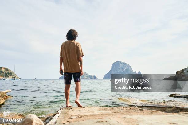man looking towards es vedra at sunset, ibiza, balearic islands, spain - the isle of man tt races stockfoto's en -beelden