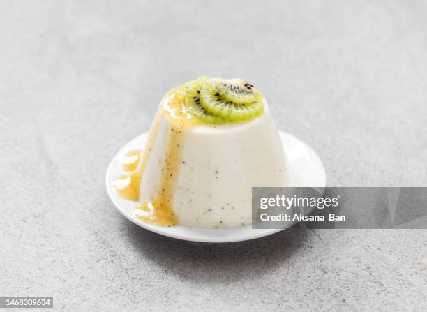 vegan dessert. kiwi cream panna cotta with kiwi sauce, on a plate. light gray background - panna cotta photos et images de collection
