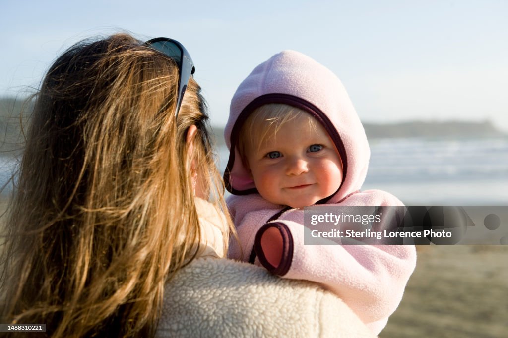 Beach play for mother and daughter baby girl at Cox bay, Tofino, British Columbia