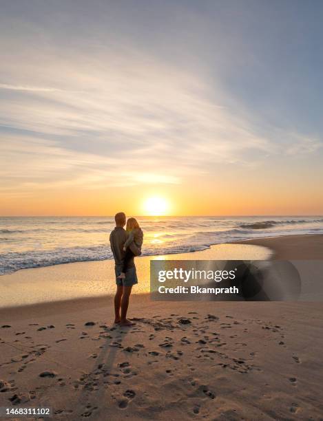 vater und kleinkind genießen einen wunderschönen sonnenaufgang am playa linda beach über dem atlantischen ozean auf merritt island national wildlife refuge florida - sunrise beach stock-fotos und bilder