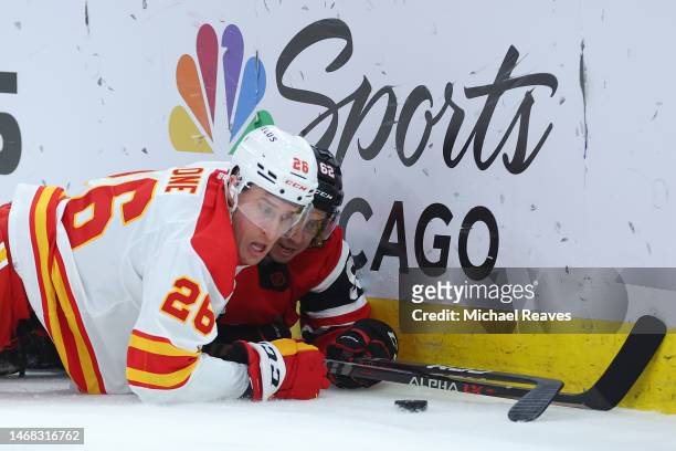 Michael Stone of the Calgary Flames and Brett Seney of the Chicago Blackhawks battle for the puck at United Center on January 08, 2023 in Chicago,...