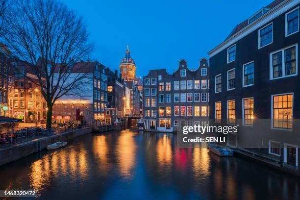 amsterdam night, red light district night with colorful windows near the basilica of saint nicholas - amstel stockfoto's en -beelden