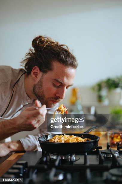 chefkoch probiert pasta mit frischem gemüse - chef smelling food stock-fotos und bilder