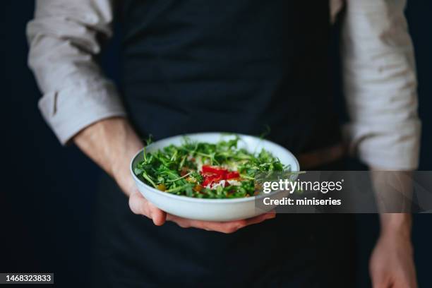 close up photo of man’s hand holding salad bowl - apron stock pictures, royalty-free photos & images