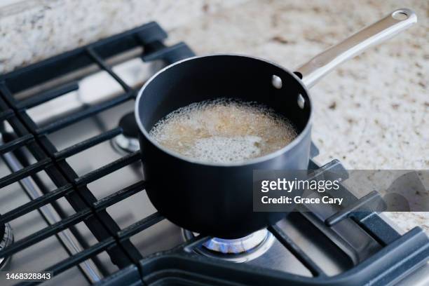 food boils in pot on gas cooktop - arroz integral fotografías e imágenes de stock