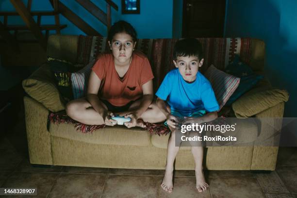 the thrill of gaming: a boy and a teen girl engrossed in their virtual adventure - gaming station stock pictures, royalty-free photos & images