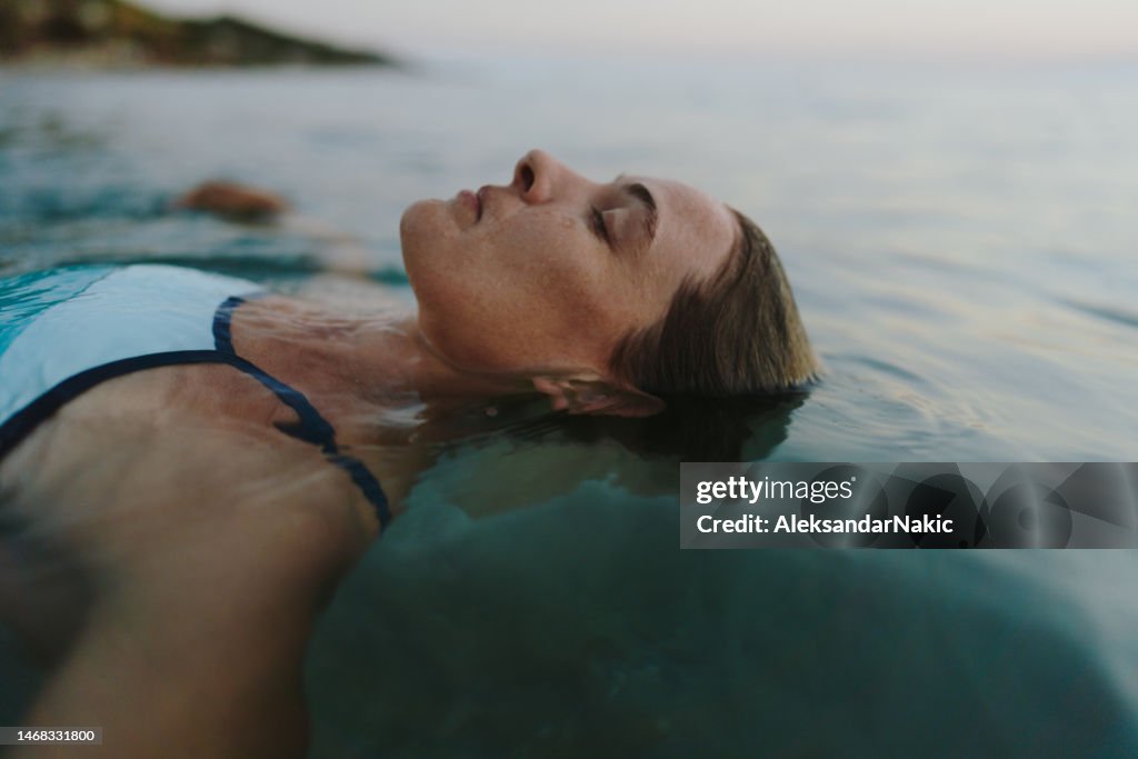 Frau im mittleren Erwachsenenalter, die im Meer schwimmt