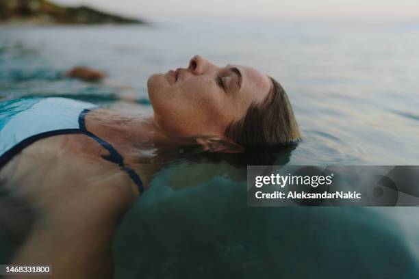 mid-adult woman swimming in the sea - beach relax stock pictures, royalty-free photos & images