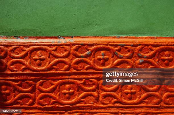 detail of a colonial building exterior wall painted green and orange and featuring an abstract decorative relief pattern of flourishes and crosses - colombia pattern stock pictures, royalty-free photos & images