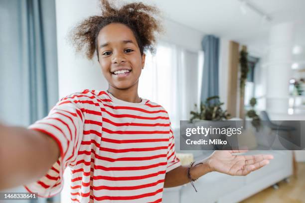 teenage girl talking on a video call and looking at the camera - very young webcam girls stockfoto's en -beelden