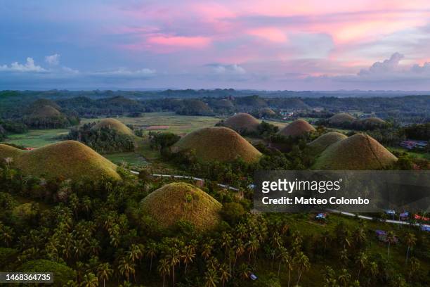 aerial view of the chocolate hills at sunset, bohol, philippines - bohol philippines stock pictures, royalty-free photos & images