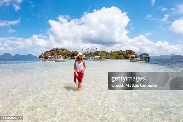 woman relaxing on a sandbar near island - sarong stock-fotos und bilder