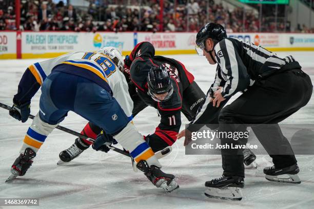 Jordan Staal of the Carolina Hurricanes faces off with Robert Thomas of the St. Louis Blues during the third period at PNC Arena on February 21, 2023...