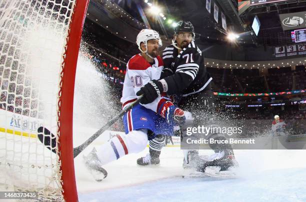 Jonas Siegenthaler of the New Jersey Devils defends against Alex Belzile of the Montreal Canadiens at the Prudential Center on February 21, 2023 in...