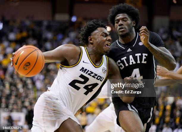 Kobe Brown of the Missouri Tigers drives to the basket as he is defended by Cameron Matthews of the Mississippi State Bulldogs in the second half at...