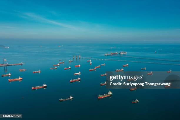 aerial view oil ship tanker park on the sea at dusk waiting for load or unload oil at loading dock from refinery, energy or oil industry concept. - camion citerne photos et images de collection