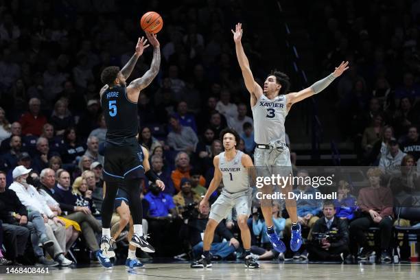 Justin Moore of the Villanova Wildcats attempts a shot while being guarded by Colby Jones of the Xavier Musketeers in the first half at the Cintas...