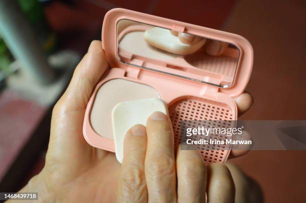 woman using make-up compact powder - powder puff stock pictures, royalty-free photos & images