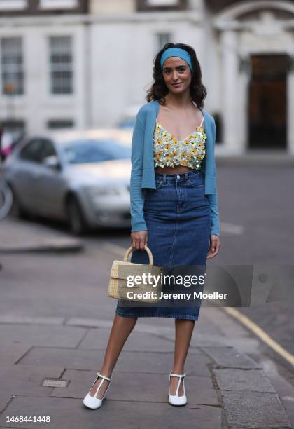 Juny Breeze seen wearing a denim long midi skirt, a cropped sequins flower top, a blue cardigan, a blue hairband, a yellow bag and white heels before...