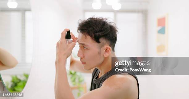 el hombre usa el tónico para crecer el cabello - receding hairline fotografías e imágenes de stock