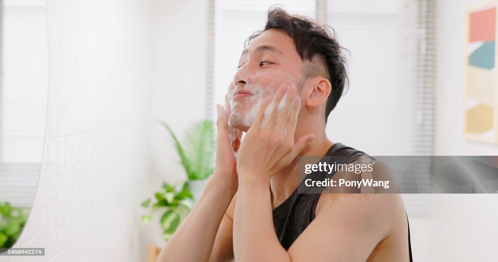 Hombre lavándose la cara con espuma