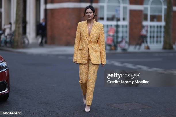 Lilah Parsons seen wearing a matching yellow flower patterned suit and high heels before the PAUL and JOE show during London Fashion Week on February...