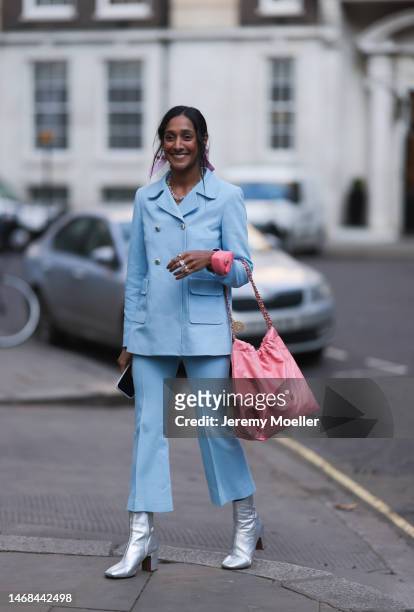 Zeena Shahseen wearing a pink Chanel mini heart bag, a matching pink Chanel 22 bag, a blue matching suit with an oversized blazer and wide leg pants,...