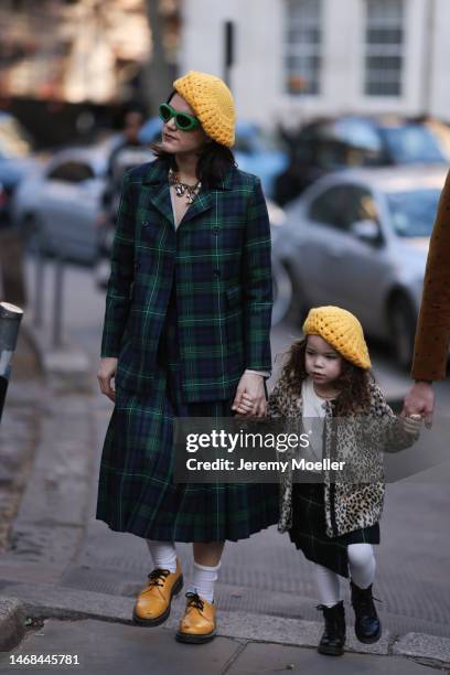 Soko seen wearing a yellow knit beret, green shades, a checked green blazer and matching pleated skirt, white socks and yellow shoes and another...