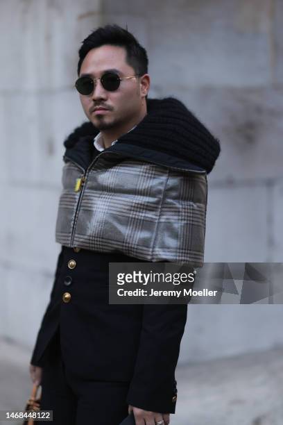 Fashion week guest seen wearing a Louis Vuitton bag, a Fendi checked down cape, dark shades, black pants and a black jacket with a fur collar before...