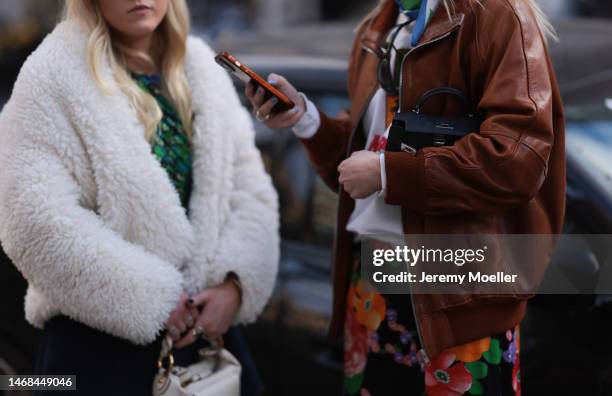 Fashion week guest seen wearing a Hermes mini kelly bag, a brown leather jacket, a colourful flower printed skirt and hairclips and another fashion...