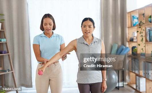 Physiotherapist, physiotherapy and woman with dumbbell exercise for strength recovery. Weight workout, clinic consulting and Asian patient with doctor for rehabilitation, training or physical therapy Physiotherapist, physiotherapy and woman with dumbbell exercise for strength recovery. Weight workout, clinic consulting and Asian patient with doctor for rehabilitation, training or physical therapy