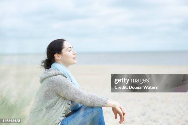 woman sitting at beach with eyes closed. - dougal waters 個照片及圖片檔