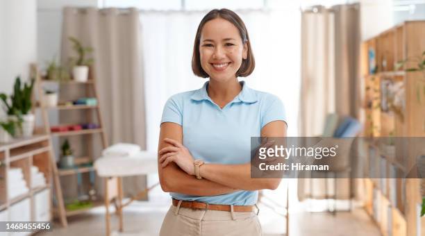 woman, portrait and smile of physiotherapist with arms crossed in clinic ready for physiotherapy. physical therapy, healthcare and happy, proud and confident asian female chiropractor from japan. - osteopath stock pictures, royalty-free photos & images
