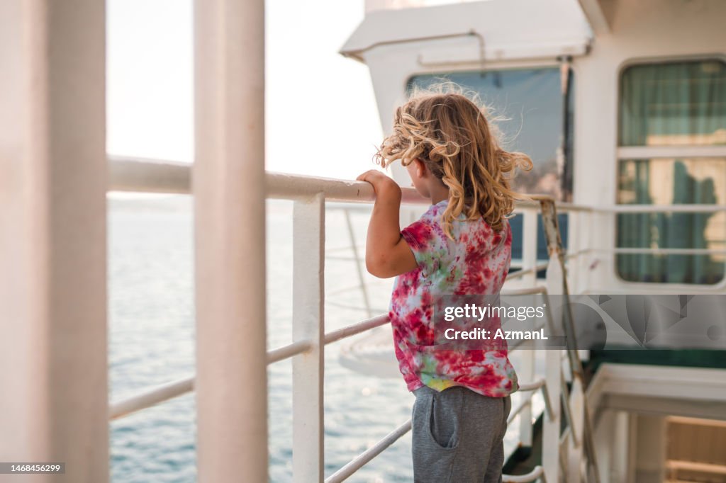 Cute Small Boy Looking into The Horizon while Sailing