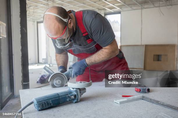 mid adult worker cutting tiles - blue collar worker mask stock pictures, royalty-free photos & images