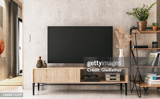 A nostalgic retro living room with a TV on a cabinet and book shelves in front of a textured ruined gray plaster wall A nostalgic retro living room with a TV on a cabinet and book shelves in front of a textured ruined gray plaster wall