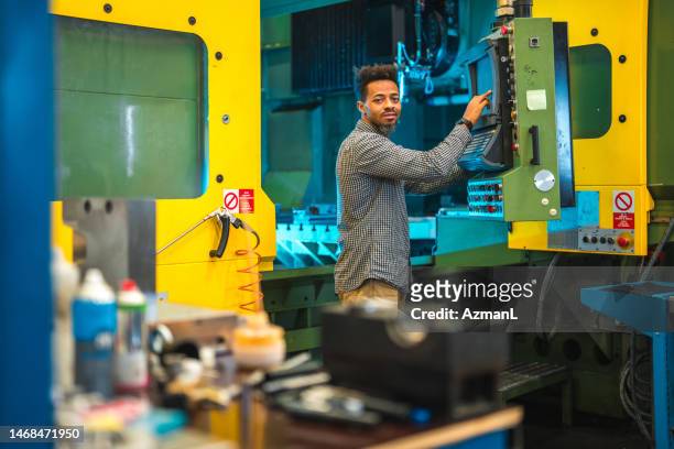 mid adult black male pressing control buttons on a cnc machine - switchboard operator stock pictures, royalty-free photos & images