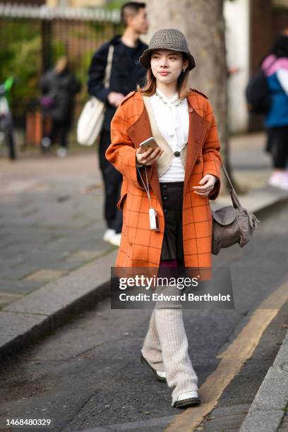 Guest wears a dark brown and black / camel houndstooth print pattern wool hat, gold and white pearls earrings, a white lace print pattern collar...