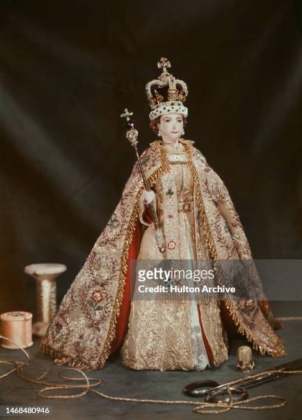 Doll of Queen Elizabeth II in coronation gown, crown and scepter, with gold thread, thimble and scissors, London, circa 1953.