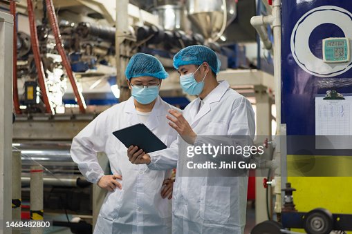 Two technicians looking at a tablet discussing data Two technicians looking at a tablet discussing data