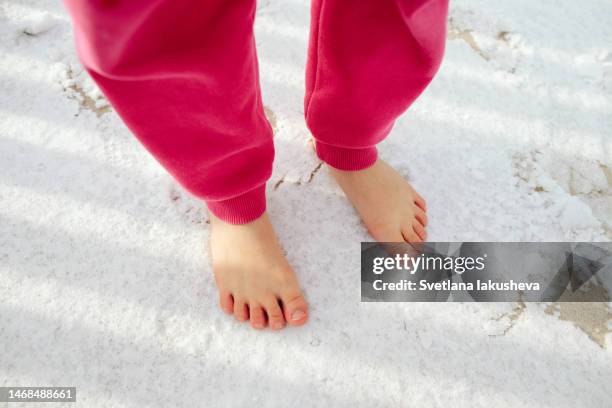 the girl stands barefoot in the snow on the terrace - barfuß im schnee stock-fotos und bilder