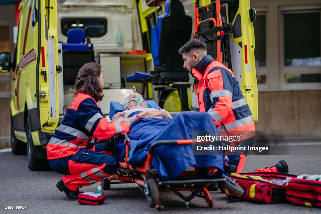 Rescuers taking care of senior woman patient.